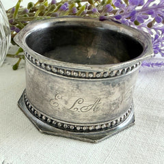 Antique silver‑plated napkin ring with beaded borders and engraved E.L.A. No. 3.
