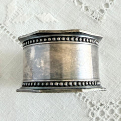 Antique silver‑plated napkin ring with beaded borders and engraved E.L.A. No. 3.