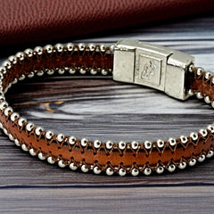 Erica Zap signed brown leather bracelet with silver-tone beaded edges and a textured magnetic clasp, modern artisan design in very good condition.