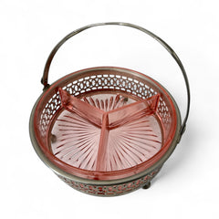 Vintage Farberware relish dish featuring pink Depression glass in a divided three-section design, set in a silver-tone openwork metal basket with arched handle and pedestal base; photographed in soft light to highlight its rosy hue and Art Deco detailing.