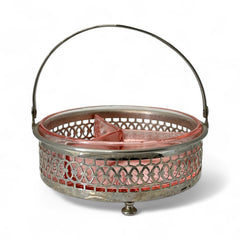 Vintage Farberware relish dish featuring pink Depression glass in a divided three-section design, set in a silver-tone openwork metal basket with arched handle and pedestal base; photographed in soft light to highlight its rosy hue and Art Deco detailing.