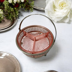 Vintage Farberware relish dish featuring pink Depression glass in a divided three-section design, set in a silver-tone openwork metal basket with arched handle and pedestal base; photographed in soft light to highlight its rosy hue and Art Deco detailing.