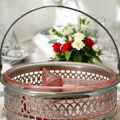 Vintage Farberware relish dish featuring pink Depression glass in a divided three-section design, set in a silver-tone openwork metal basket with arched handle and pedestal base; photographed in soft light to highlight its rosy hue and Art Deco detailing.