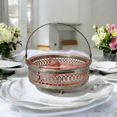 Vintage Farberware relish dish featuring pink Depression glass in a divided three-section design, set in a silver-tone openwork metal basket with arched handle and pedestal base; photographed in soft light to highlight its rosy hue and Art Deco detailing.