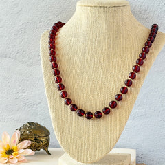 Vintage cherry amber acrylic bead necklace with gold tone spacers and clasp displayed on neutral background.
