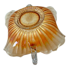 Vintage Fenton marigold carnival glass dish with stippled rays pattern, featuring a ruffled scalloped edge and clear double handles; warm amber iridescence with visible air bubbles 