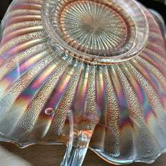 Vintage Fenton marigold carnival glass dish with stippled rays pattern, featuring a ruffled scalloped edge and clear double handles; warm amber iridescence with visible air bubbles 