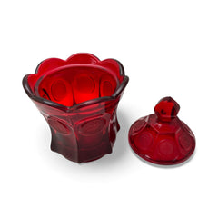 Vintage Fostoria Ruby Red Coin Glass candy dish with lid, featuring embossed coin medallions and a pointed finial; shown in rich red pressed glass with original Fostoria sticker, styled to highlight its collectible elegance and mid-century provenance.