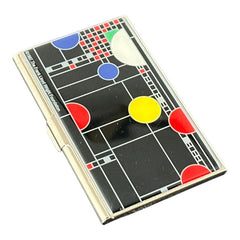 Acme Studio business/credit card case featuring Frank Lloyd Wright's 'Playhouse' design, showcasing geometric patterns with red, yellow, and blue accents on a black background, crafted with mirror chrome metal finish and lacquer-filled acid-etched image.
