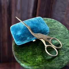 Antique French stork-shaped embroidery scissors from the late 1800s to early 1900s. Crafted with intricate details, the silver-tone finish shows charming wear, revealing darker metal and hints of faded gold-tone accents on the stork’s body when opened. A collectible and decorative piece embodying timeless craftsmanship and vintage elegance.