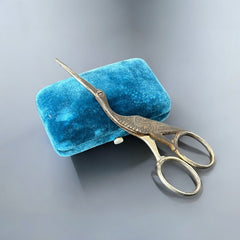 Antique French stork-shaped embroidery scissors from the late 1800s to early 1900s. Crafted with intricate details, the silver-tone finish shows charming wear, revealing darker metal and hints of faded gold-tone accents on the stork’s body when opened. A collectible and decorative piece embodying timeless craftsmanship and vintage elegance.