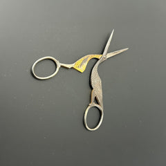 Antique French stork-shaped embroidery scissors from the late 1800s to early 1900s. Crafted with intricate details, the silver-tone finish shows charming wear, revealing darker metal and hints of faded gold-tone accents on the stork’s body when opened. A collectible and decorative piece embodying timeless craftsmanship and vintage elegance.