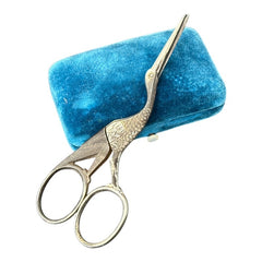 Antique French stork-shaped embroidery scissors from the late 1800s to early 1900s. Crafted with intricate details, the silver-tone finish shows charming wear, revealing darker metal and hints of faded gold-tone accents on the stork’s body when opened. A collectible and decorative piece embodying timeless craftsmanship and vintage elegance.