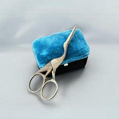 Antique French stork-shaped embroidery scissors from the late 1800s to early 1900s. Crafted with intricate details, the silver-tone finish shows charming wear, revealing darker metal and hints of faded gold-tone accents on the stork’s body when opened. A collectible and decorative piece embodying timeless craftsmanship and vintage elegance.