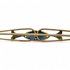 Vintage French Art Deco bar brooch with blue marquise rhinestone, gold-plated metal, and silver-tone leaf accents