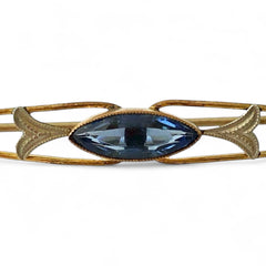 Vintage French Art Deco bar brooch with blue marquise rhinestone, gold-plated metal, and silver-tone leaf accents
