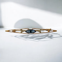 Vintage French Art Deco bar brooch with blue marquise rhinestone, gold-plated metal, and silver-tone leaf accents