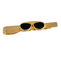 Vintage French gold‑tone tie clip with black enamel sunglasses motif from the 1980s.