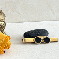 Vintage French gold‑tone tie clip with black enamel sunglasses motif from the 1980s.