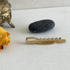 Vintage French gold‑tone tie clip with black enamel sunglasses motif from the 1980s.
