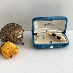 Vintage French gold‑tone tie clip with black enamel sunglasses motif from the 1980s.