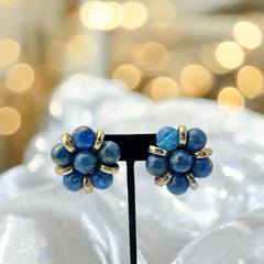 Vintage French clip-on earrings featuring marbled blue plastic beads with gold veining, arranged in a floral cluster with gold-tone rondelles, 1970s–1980s design, shown in very good condition.
