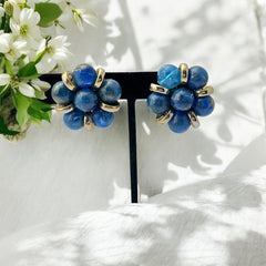 Vintage French clip-on earrings featuring marbled blue plastic beads with gold veining, arranged in a floral cluster with gold-tone rondelles, 1970s–1980s design, shown in very good condition.