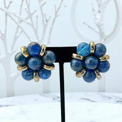 Vintage French clip-on earrings featuring marbled blue plastic beads with gold veining, arranged in a floral cluster with gold-tone rondelles, 1970s–1980s design, shown in very good condition.