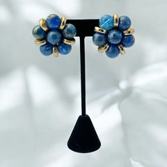Vintage French clip-on earrings featuring marbled blue plastic beads with gold veining, arranged in a floral cluster with gold-tone rondelles, 1970s–1980s design, shown in very good condition.
