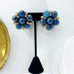 Vintage French clip-on earrings featuring marbled blue plastic beads with gold veining, arranged in a floral cluster with gold-tone rondelles, 1970s–1980s design, shown in very good condition.