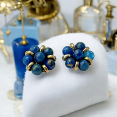 Vintage French clip-on earrings featuring marbled blue plastic beads with gold veining, arranged in a floral cluster with gold-tone rondelles, 1970s–1980s design, shown in very good condition.
