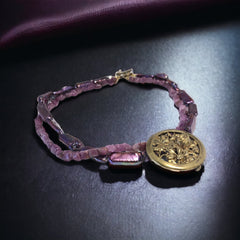 Necklace with vintage 1930s French gold‑tone floral brooch pendant on two strands of purple‑pink dyed stick pearls and rough rubies, shown from multiple angles.