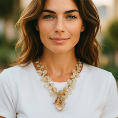 Vintage French necklace from the 1980s featuring iridescent acrylic beads, frosted and clear leaf accents, gold-tone metal details, and a central faceted pear-shaped drop with floral embellishment. Nature-inspired design in very good vintage condition