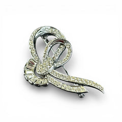Vintage French bow brooch with clear rhinestones in rhodium-plated metal, featuring pavé chatons and baguettes in a sculptural 1950s design.