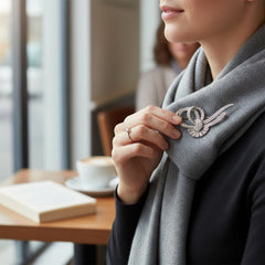 Vintage French bow brooch with clear rhinestones in rhodium-plated metal, featuring pavé chatons and baguettes in a sculptural 1950s design.