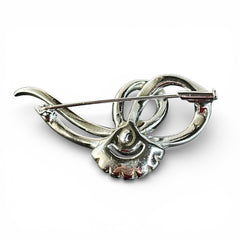 Vintage French bow brooch with clear rhinestones in rhodium-plated metal, featuring pavé chatons and baguettes in a sculptural 1950s design.