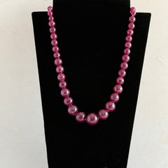 Vintage French plum‑colored graduated bead necklace with a matching screw clasp, shown on display props from multiple angles.