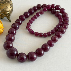 Vintage French plum‑colored graduated bead necklace with a matching screw clasp, shown on display props from multiple angles.
