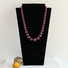 Vintage French plum‑colored graduated bead necklace with a matching screw clasp, shown on display props from multiple angles.