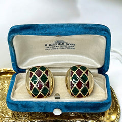 Pair of vintage French clip-on earrings with a rectangular gold-tone base, featuring a crisscross diamond lattice design filled with alternating deep red and forest green enamel; approx. 1" x ¾", late 1970s–1980s style, in very good condition with secure clips and rich color contrast.