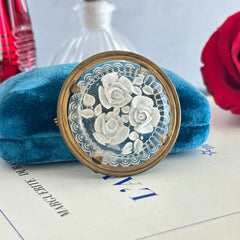 Vintage 1930s French round brooch with reverse carved Lucite floral center and gold tone metal frame, shown from various angles.