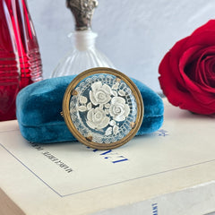 Vintage 1930s French round brooch with reverse carved Lucite floral center and gold tone metal frame, shown from various angles.
