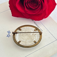 Vintage 1930s French round brooch with reverse carved Lucite floral center and gold tone metal frame, shown from various angles.