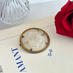 Vintage 1930s French round brooch with reverse carved Lucite floral center and gold tone metal frame, shown from various angles.
