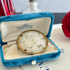 Vintage 1930s French round brooch with reverse carved Lucite floral center and gold tone metal frame, shown from various angles.