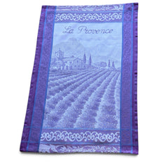 French jacquard cotton tea towel in lavender, violet, and white featuring Provençal lavender fields, farmhouse, and “La Provence” lettering. Made in France.
