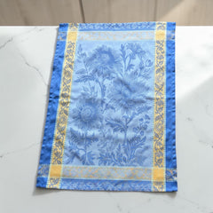 French jacquard cotton tea towel in sky blue and golden yellow featuring woven sunflower design and ornate border.