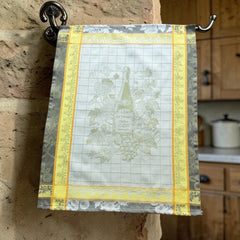 French jacquard cotton tea towel in green, yellow, and soft gray featuring a Le Vieux Chêne wine bottle surrounded by grapes and vine leaves.