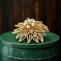 Vintage 1960s gold-tone floral brooch with openwork textured petals, featuring faux pearls and clear rhinestones on headpins at the center.