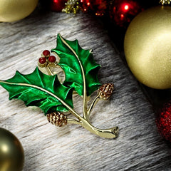 Vintage Gerry’s holly brooch with red enamel berries and metallic green enamel leaves on a gold-tone stem; signed Gerry’s on the back, 1980s holiday jewelry in very good condition with minor enamel wear.